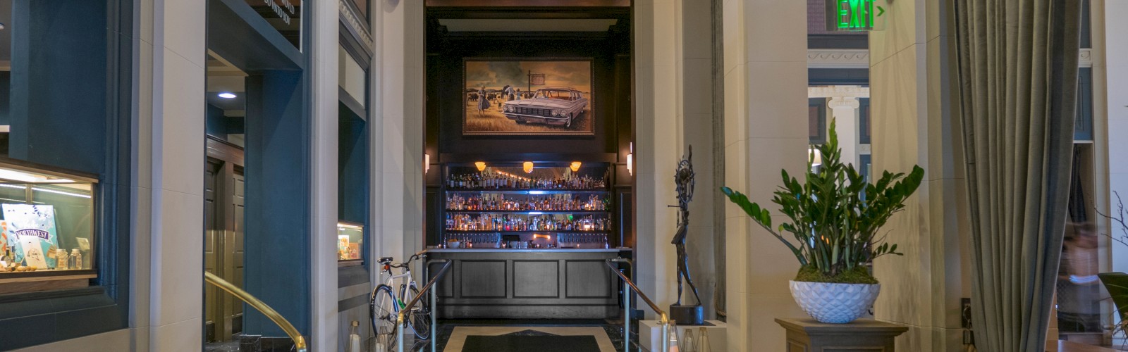 A luxurious lobby with elegant decor, a cozy sofa, indoor plants, and a reception area under a decorative ceiling.
